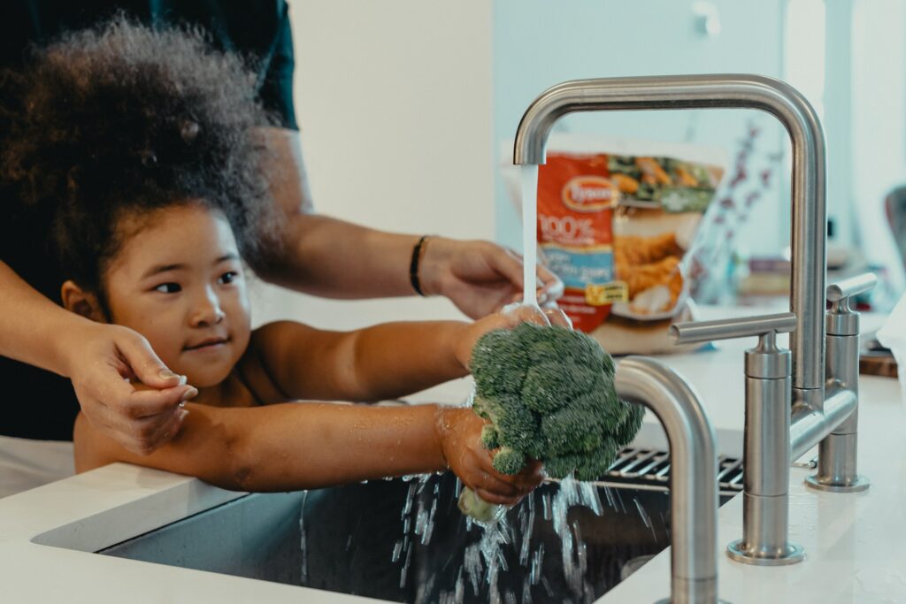 washing broccoli in the sink